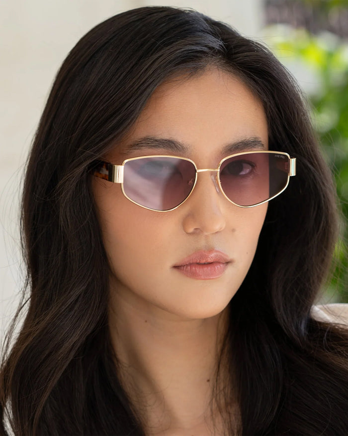 Close-up of model wearing the Freyrs Delilah Sunglasses in gold.