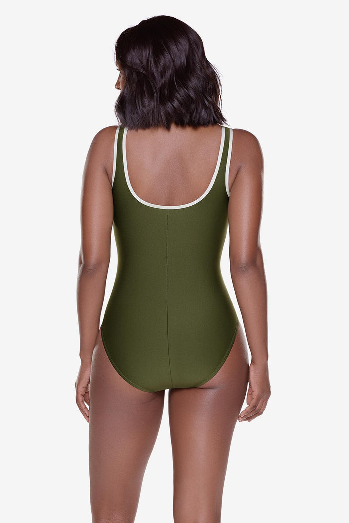 Woman turned away wearing a green one-piece swimsuit with white piping