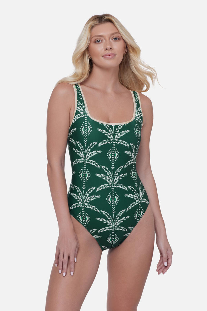 Woman wearing a green and white palm leaf printed one-piece swimsuit