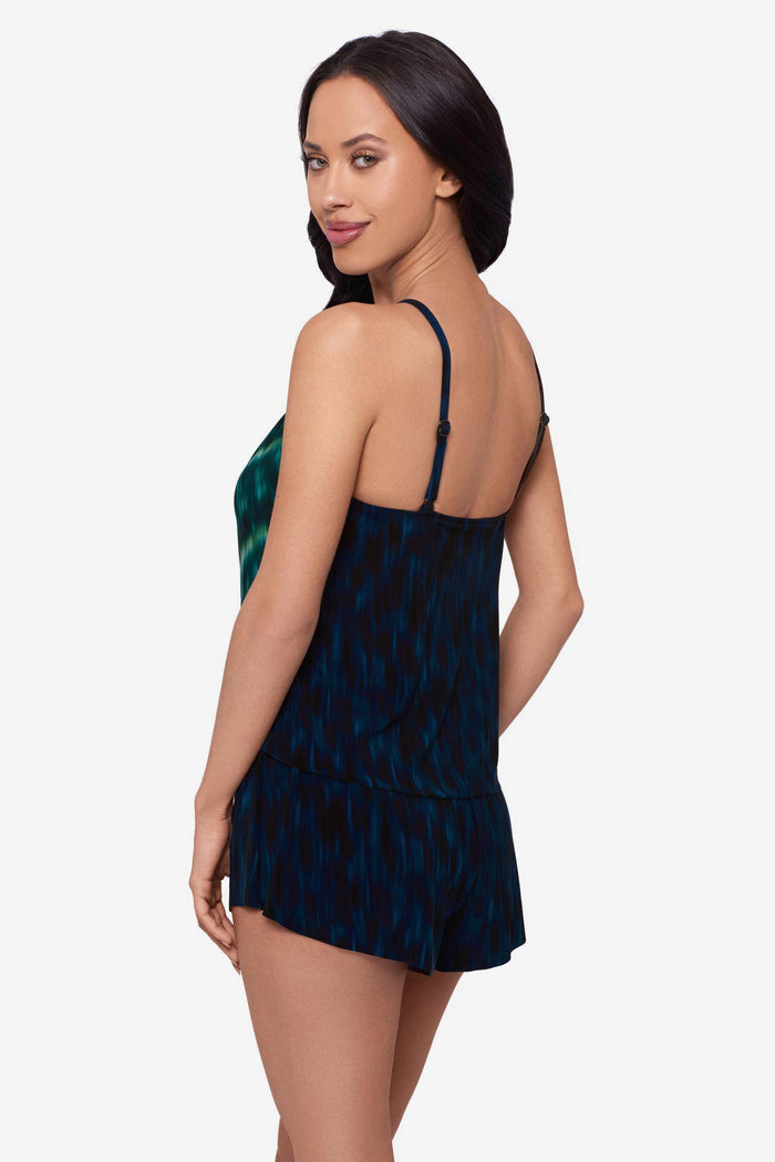 Woman turned left wearing a green tie-dyed swim romper