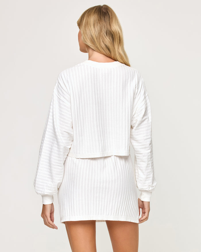 Back view of model wearing the Half Court Pullover in white with matching white Half Court Skirt.