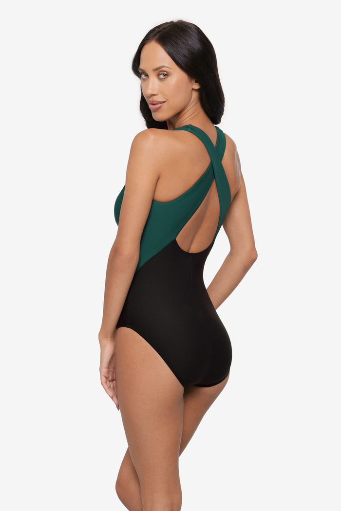 Woman turned left wearing a green and black one-piece swimsuit