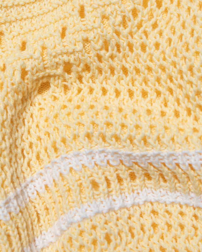 Close-up of the LSPACE Heart To Heart Dress in daisy-cream, showing the open-knit crochet fabric texture in soft yellow with a horizontal cream stripe detail.