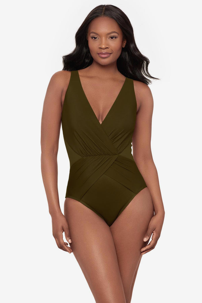 Woman wearing a green one-piece swimsuit with a V neckline