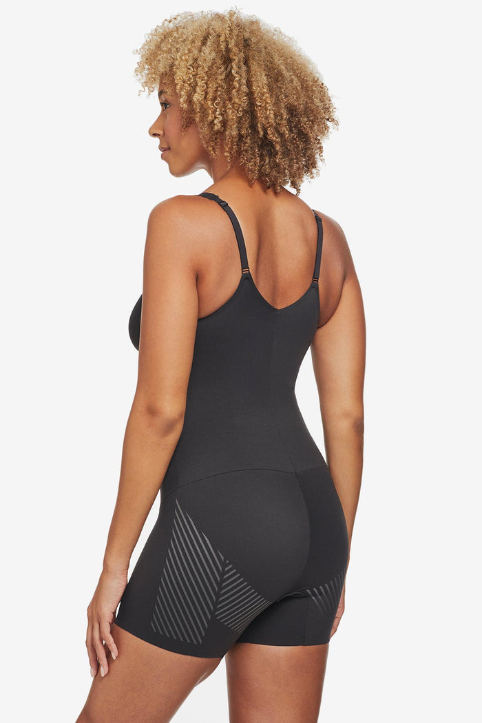 Woman turned away wearing black one-piece thigh slimming shapewear