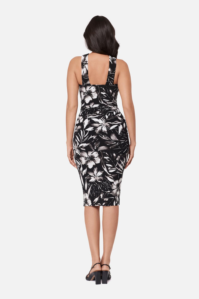 Woman turned away wearing a high neck mid length dress with a black and white floral print