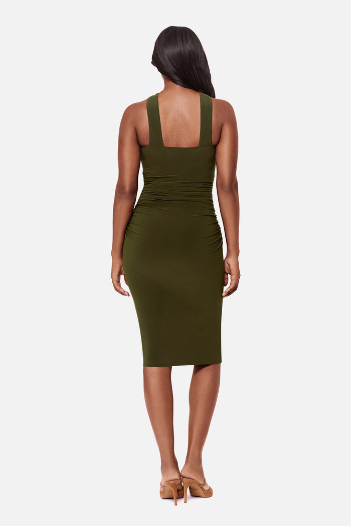 Woman turned away wearing a dark green high neck mid length dress