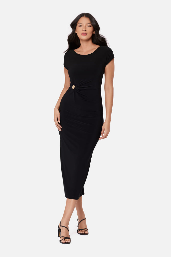 Woman wearing a black short sleeve dress with a gold tone accent on the side