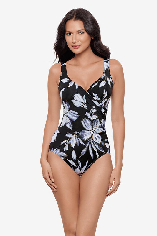 Woman wearing a black and white floral printed one-piece swimsuit with a sweetheart neckline