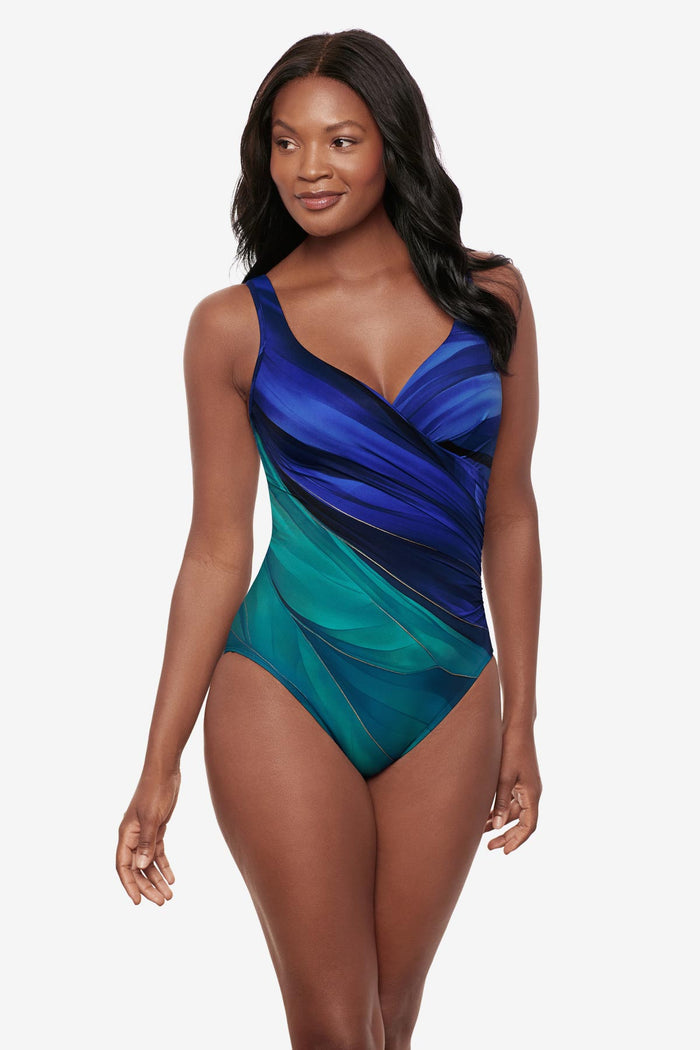 Woman wearing a multi-blue one-piece swimsuit with gold details