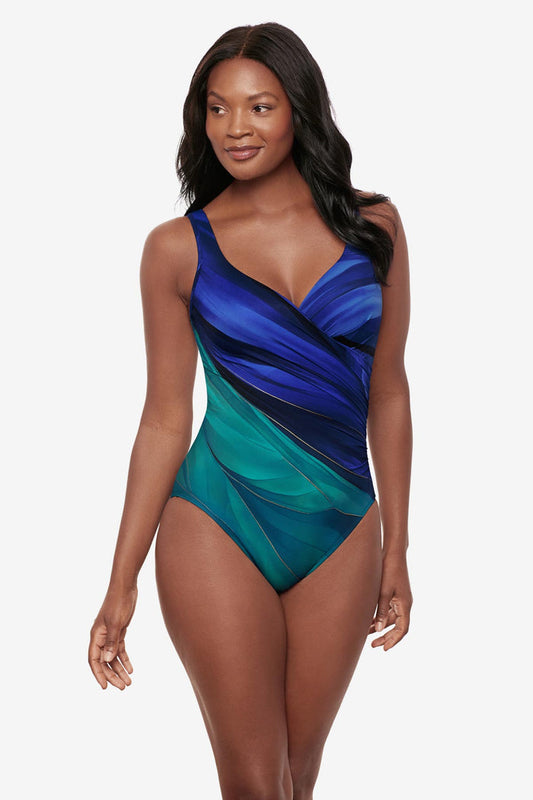 Woman wearing a multi-blue one-piece swimsuit with gold details