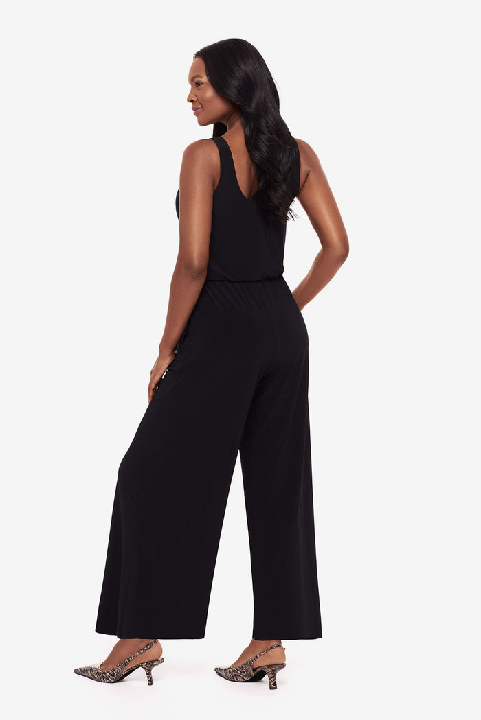 Woman turned left wearing an all black jumpsuit