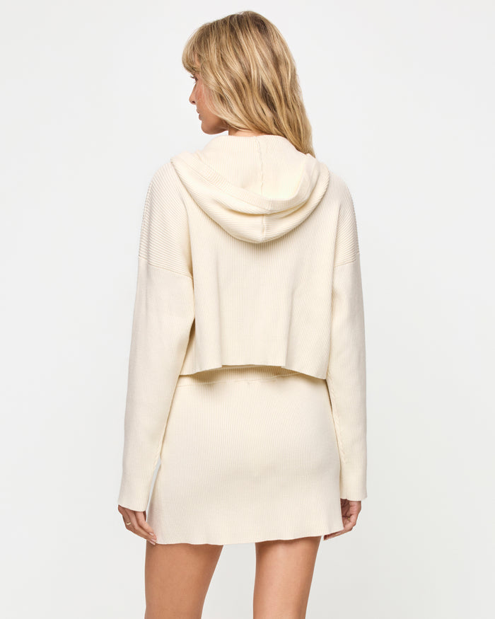 LSPACE Jet Set skirt in cream with matching hoodie, back view on model.