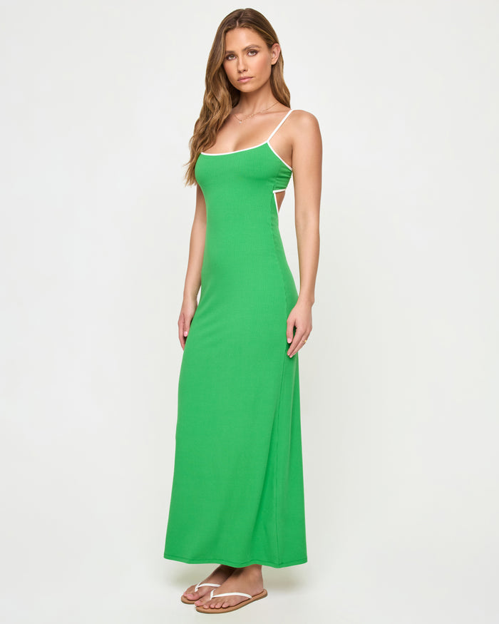 Side view of a model wearing the LSPACE Jordana Dress in clover-cream, highlighting the open back cutout detail and cream contrast trim against the clover green ribbed fabric.