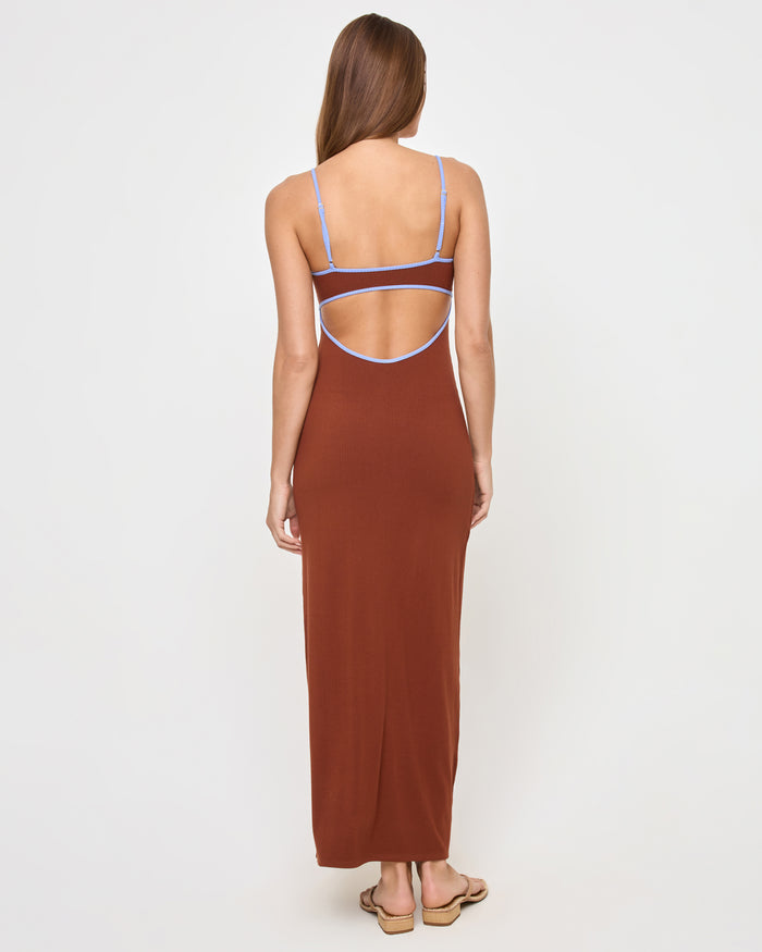 Full-length back view of a model wearing the LSPACE Jordana Dress in tobacco peri blue, showing the open-back design with periwinkle blue contrast trim on the adjustable spaghetti straps.