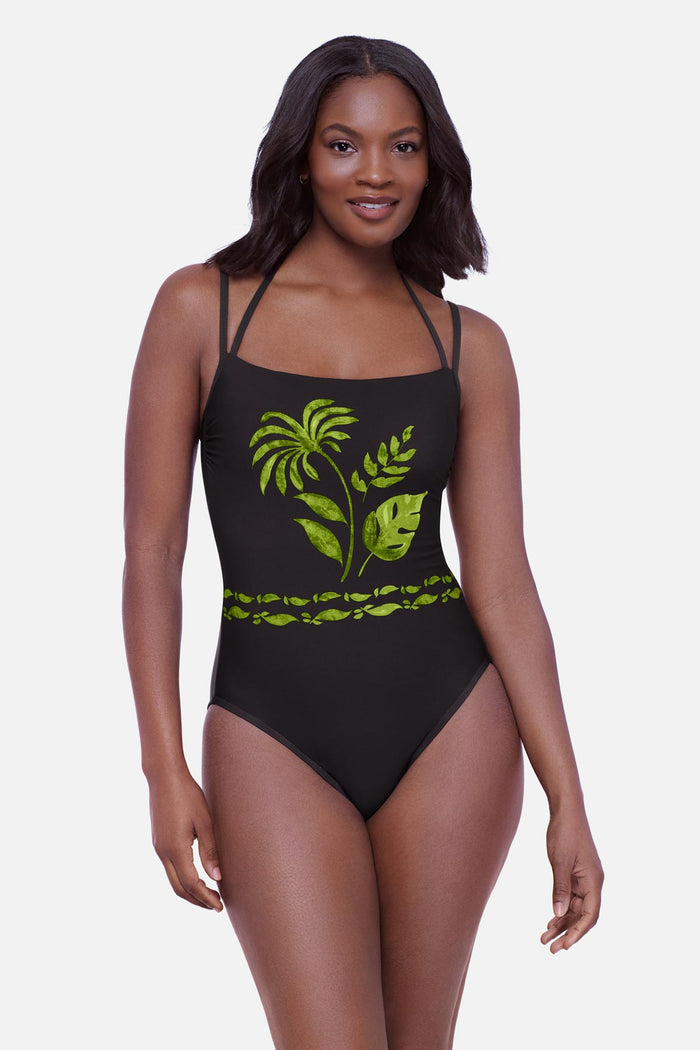 Woman wearing a one-piece swimsuit with various palm leaves on the front