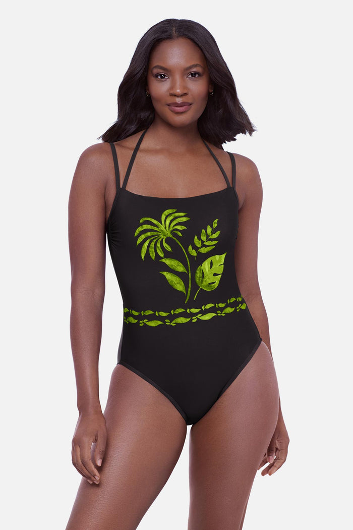 Woman wearing a one-piece swimsuit with various palm leaves on the front