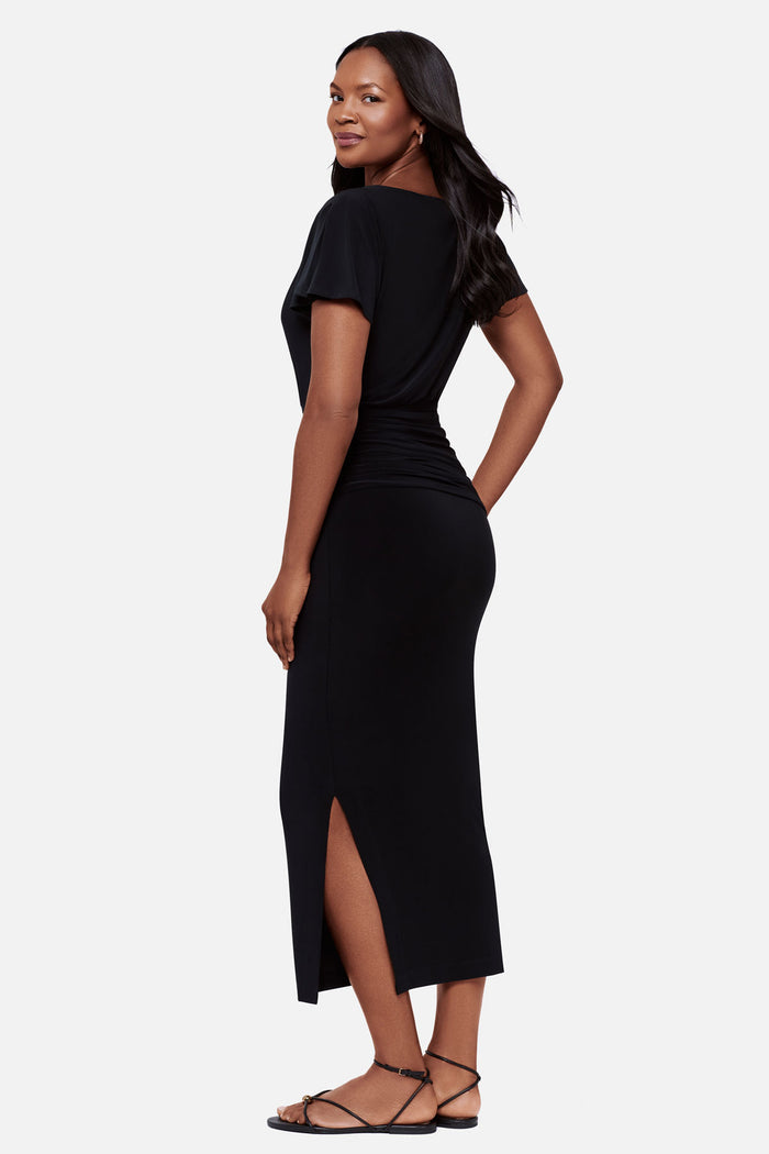 Woman faced left wearing a black short sleeve full length dress