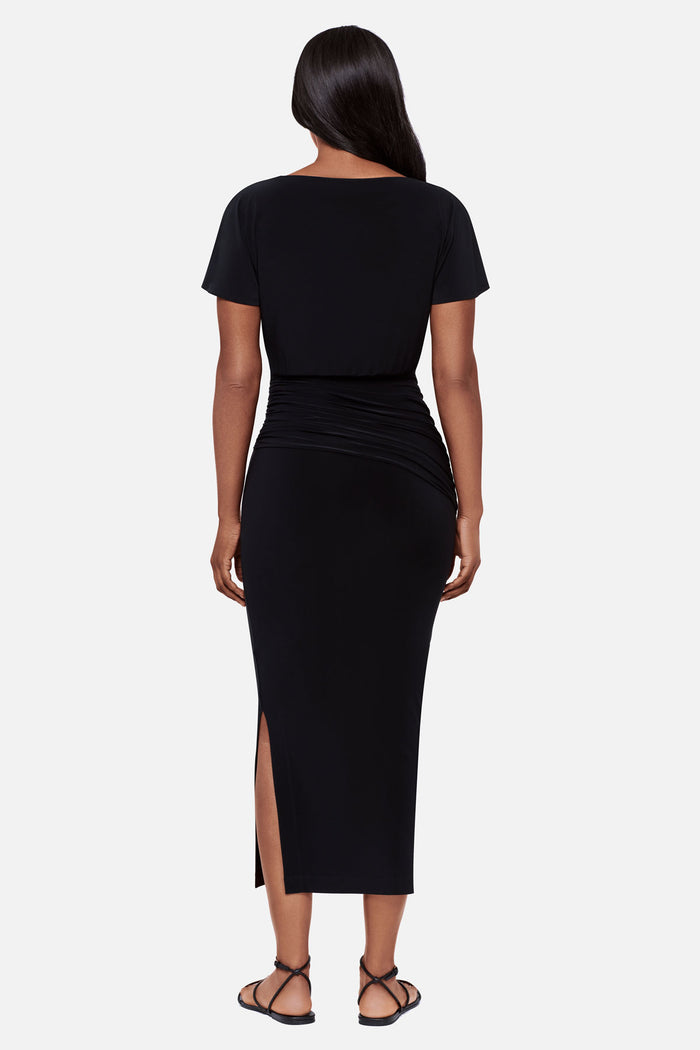 Woman faced away wearing a black short sleeve full length dress