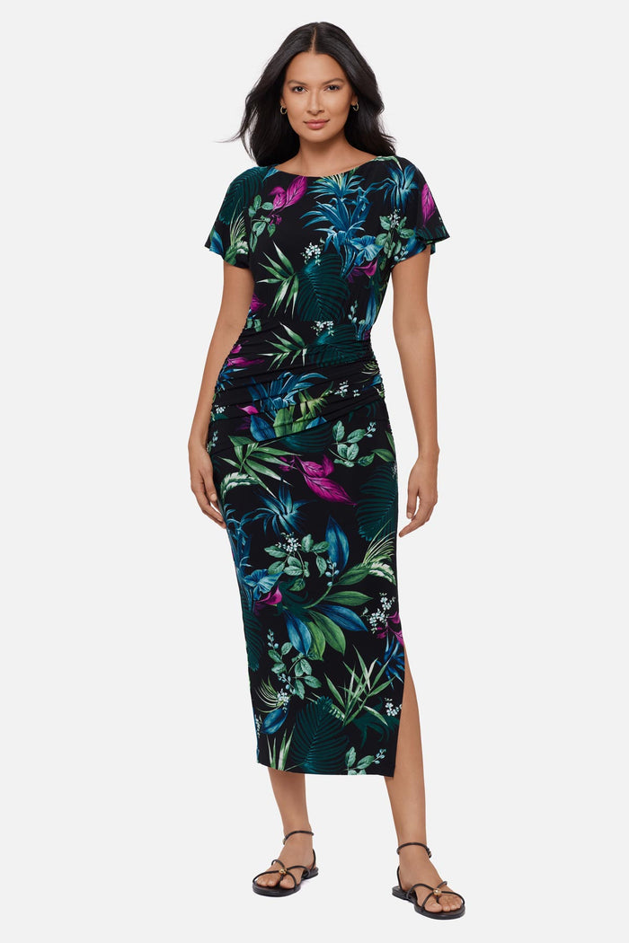 Woman wearing a multicolored tropical printed short sleeve full length dress