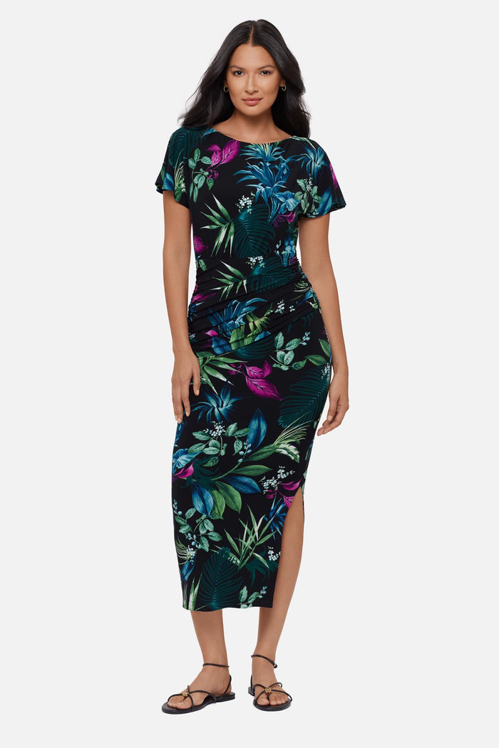 Woman wearing a multicolored tropical printed short sleeve full length dress
