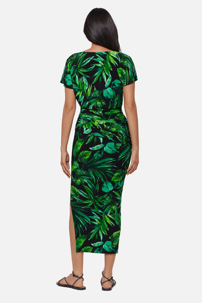 Woman turned away wearing a green palm leaf printed short sleeve full length dress