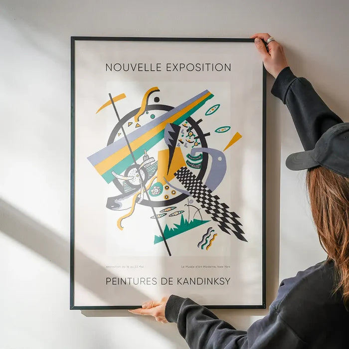 Kandinsky Nouvelle Exhibition Poster being hung on a wall in a black frame