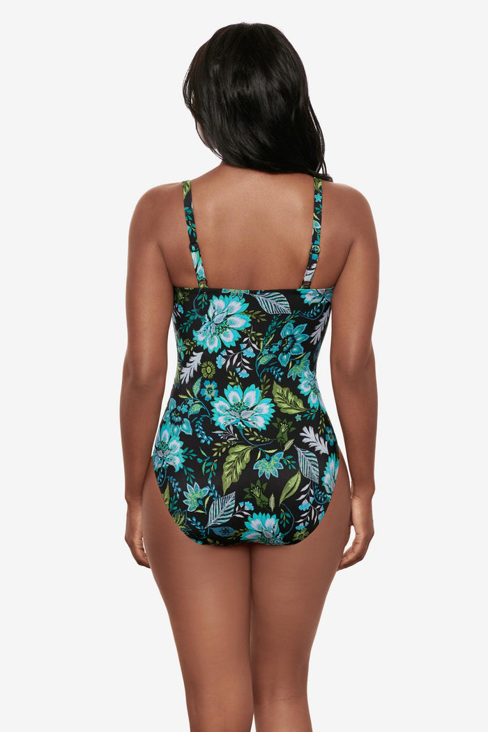 Woman turned away wearing a multicolored floral printed one-piece swimsuit
