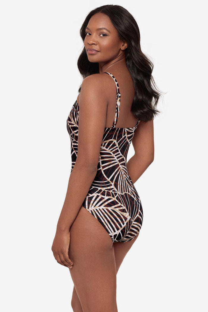 Woman turned left wearing a brown abstract printed one-piece swimsuit