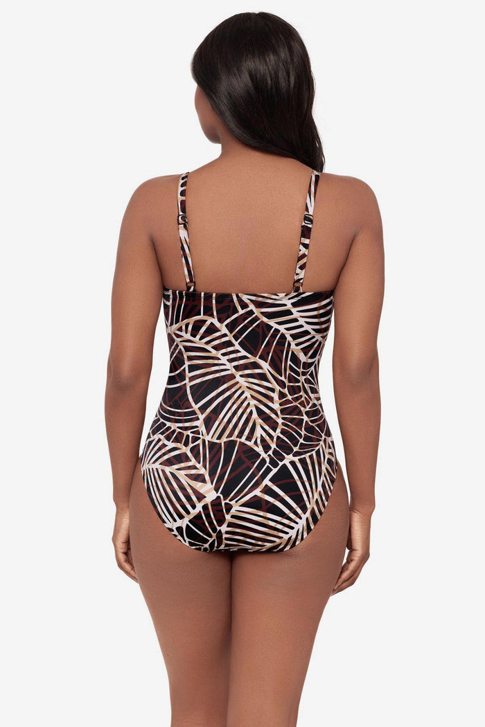 Woman turned away wearing a brown abstract printed one-piece swimsuit