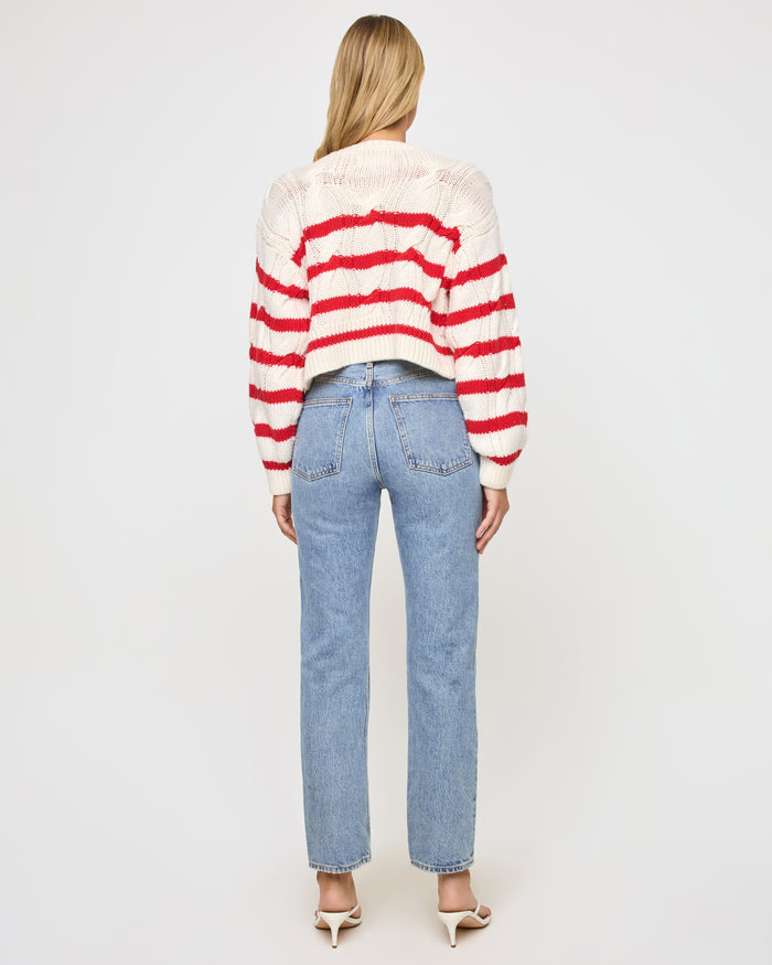 Back view of a model wearing the LSPACE Kensley Pullover in cream flame, showing the cable-knit texture and horizontal red stripe pattern across the back.