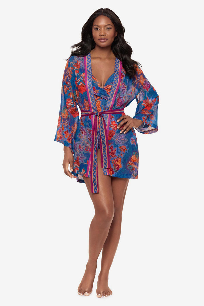 Woman wearing a multicolor floral kimono swim cover up with a matching one-piece swimsuit underneath
