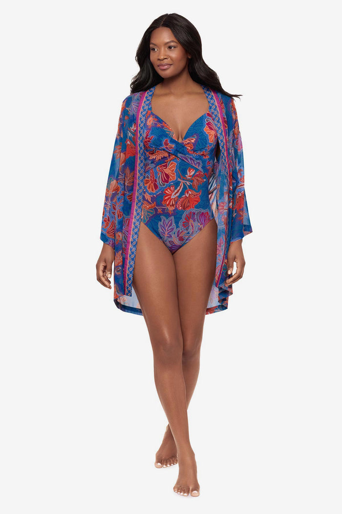 Woman wearing a multicolor floral kimono swim cover up with a matching one-piece swimsuit underneath