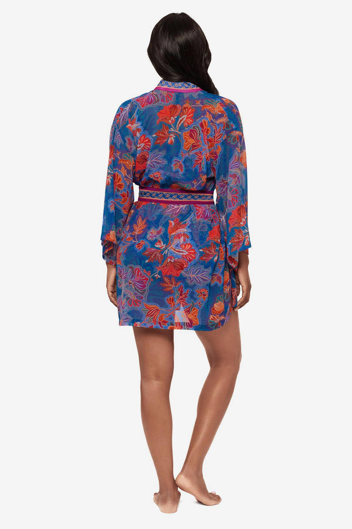 Woman turned away wearing a multicolor floral kimono swim cover up