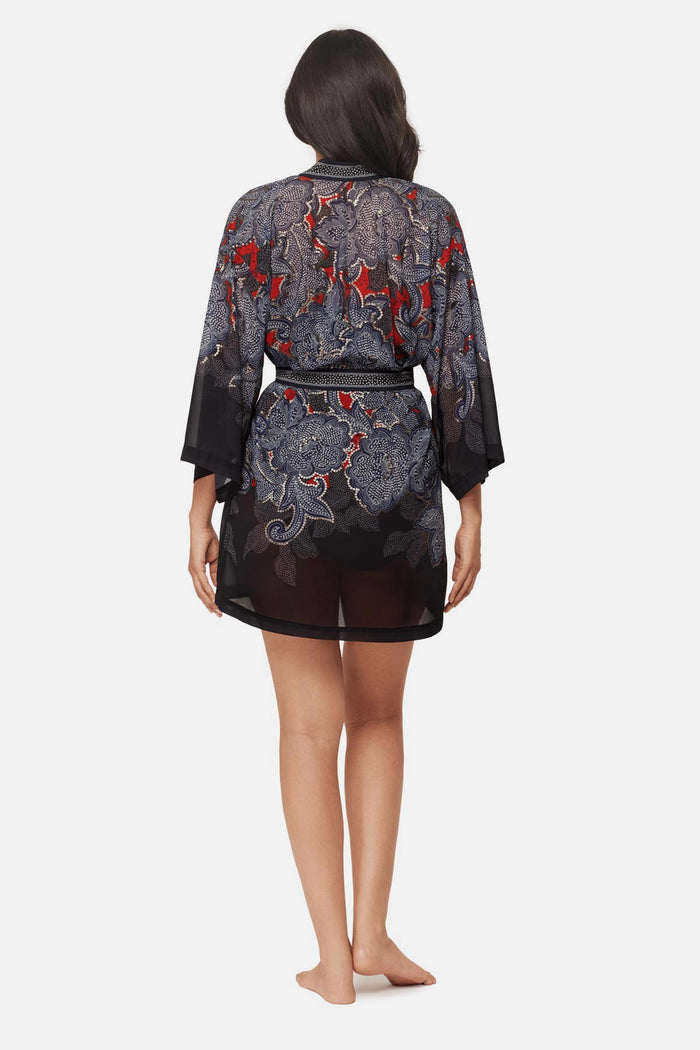 Woman faced away wearing a multicolored abstract floral printed kimono swim cover up