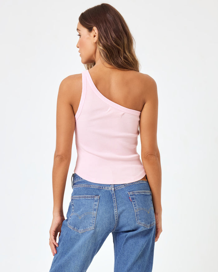 Back view of a model wearing the LSPACE Kylie Tank in petal, showing the asymmetric one-shoulder back design and bare shoulder of the blush pink ribbed crop tank.