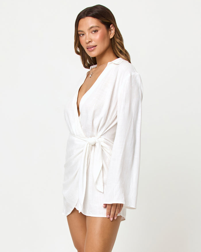 Three-quarter view of a model wearing the LSPACE Las Palmas Dress in cream, showing the V-neckline and wrap tie at the side waist.