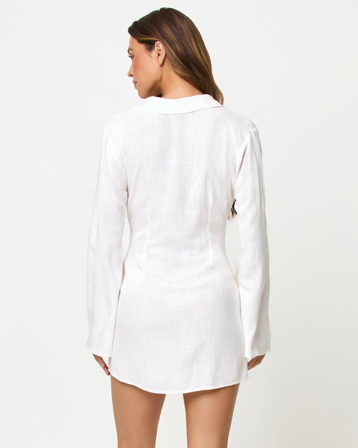 Back view of a model wearing the LSPACE Las Palmas Dress in cream, showing the collar, long flared sleeves, and smooth back panel.