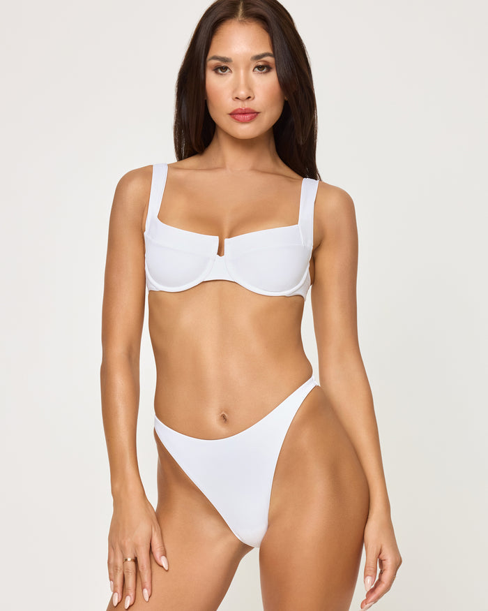 Front view of a model wearing the LSPACE white Leilani Bikini Bottom with a high-cut leg, paired with a white Mako Bikini Top.