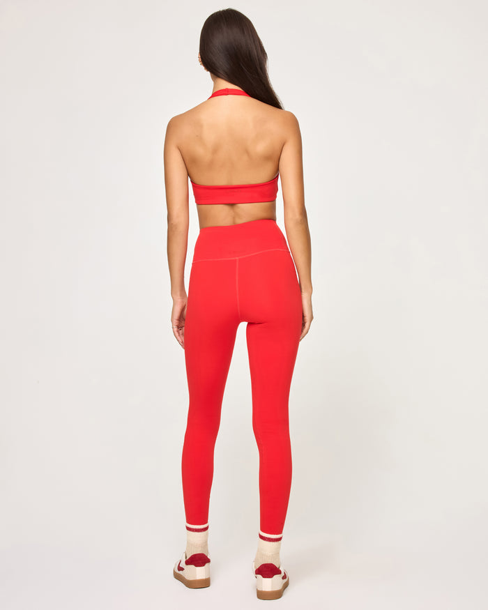 Back view of model wearing the Level Up Legging in flame with matching flame Jeanne Bra showing open halter back.