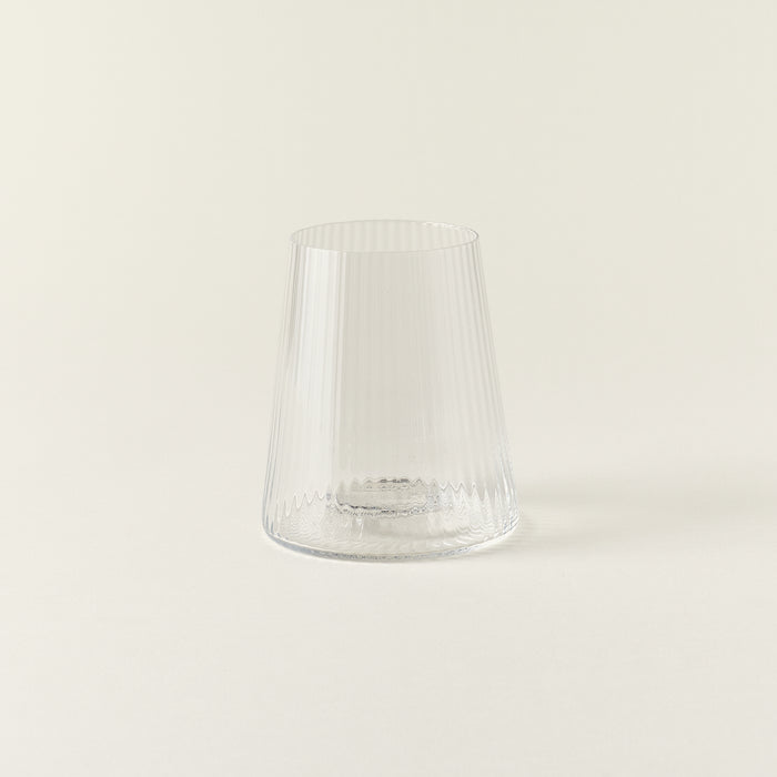 A clear drinking glass with a delicate, fluted texture and a smooth rim.