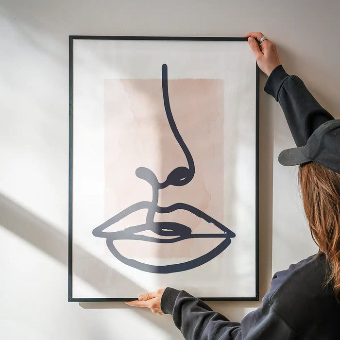 Lips Drawing Watercolour Style Print being hung on a wall in a black frame