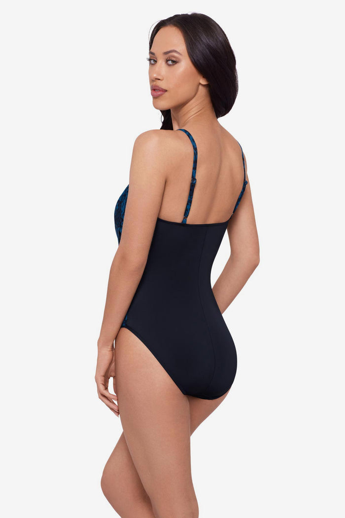 Woman turned left wearing a black and blue printed one-piece swimsuit