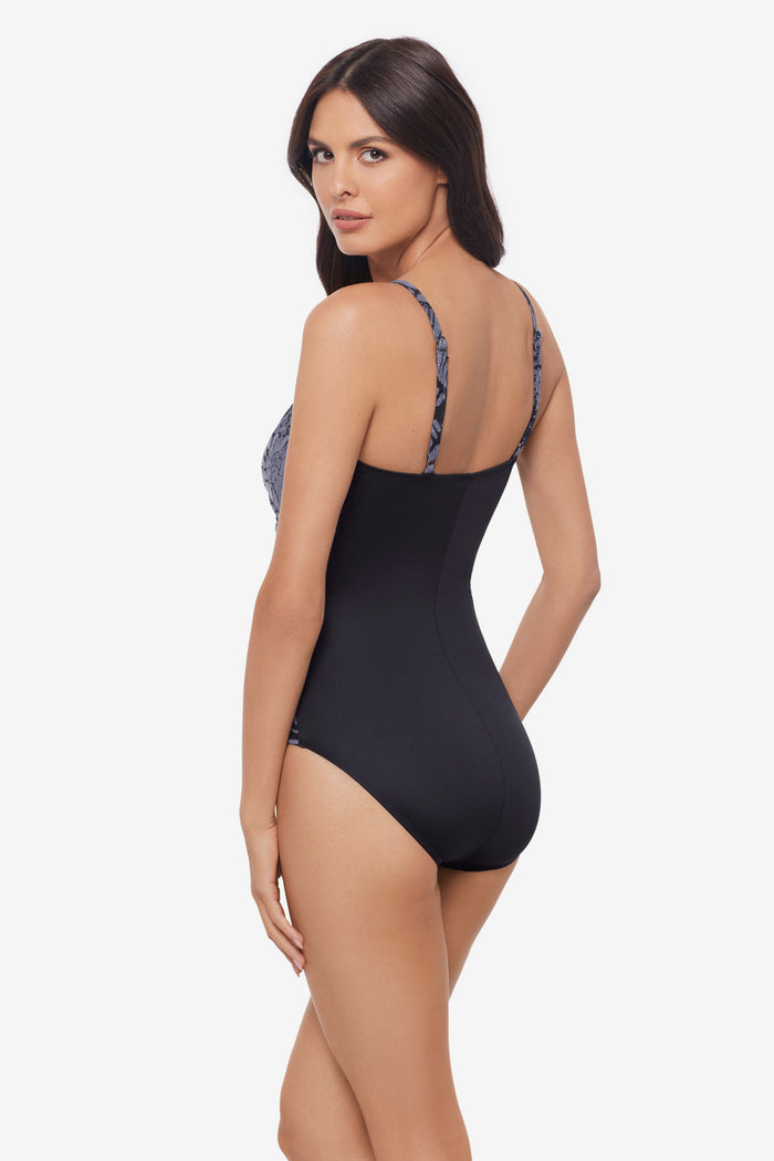 Woman turned left wearing a shimmery one-piece swimsuit