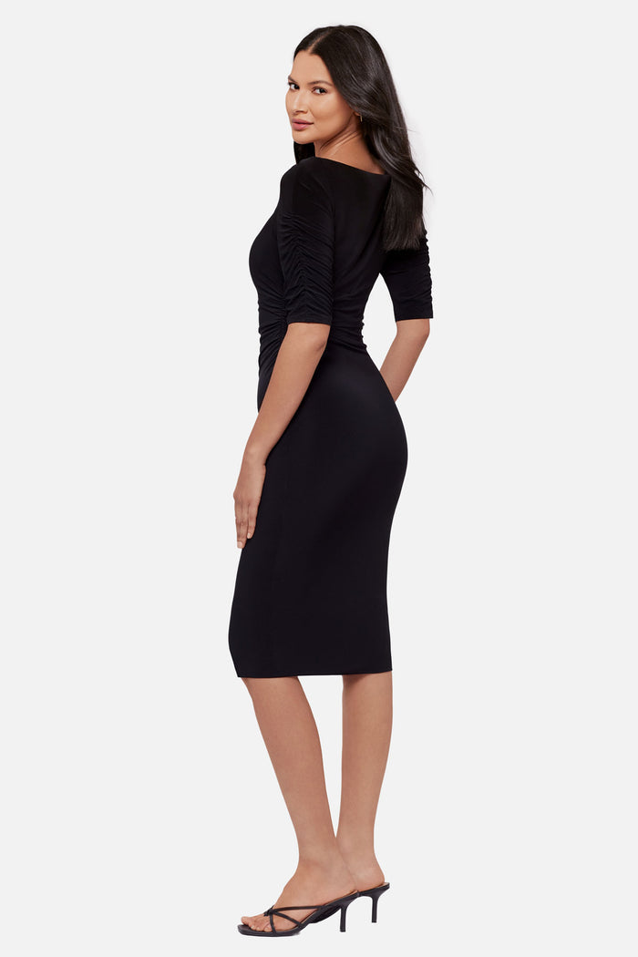 Woman turned left wearing a black half sleeve mid length dress