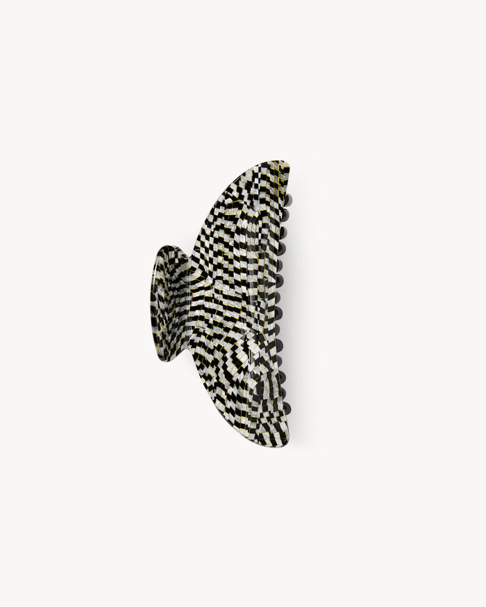Off-model side profile view of the Machete Midi Claw in perle noir, showing the black and white checkerboard acetate pattern.