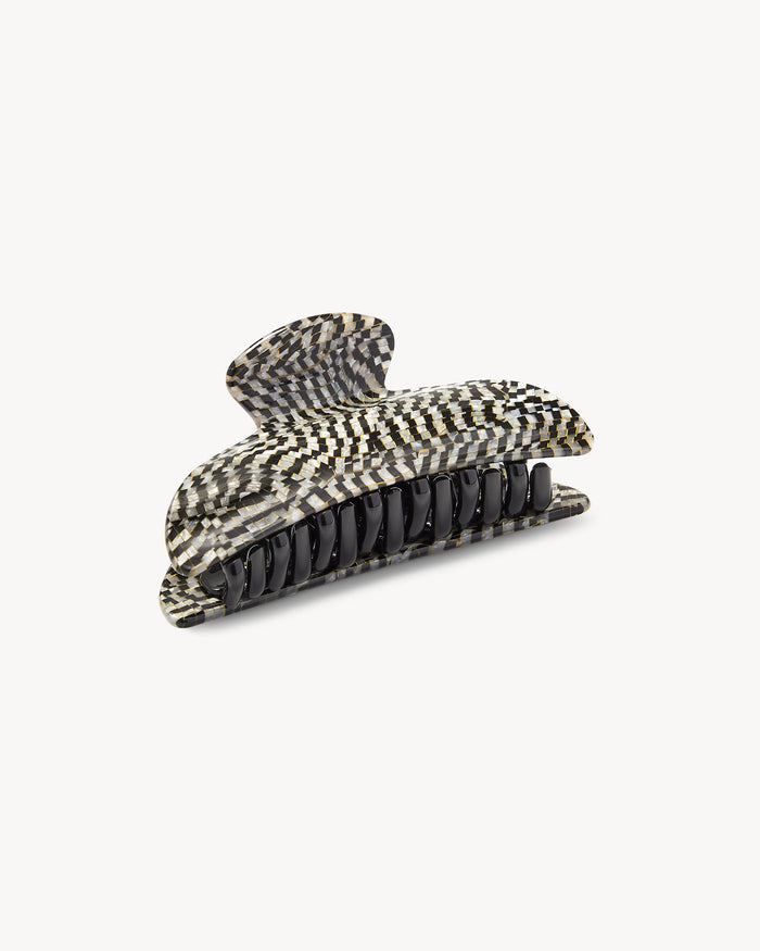 Off-model angled front view of the Machete Midi Claw in perle noir showing the teeth and black and white checkerboard acetate.
