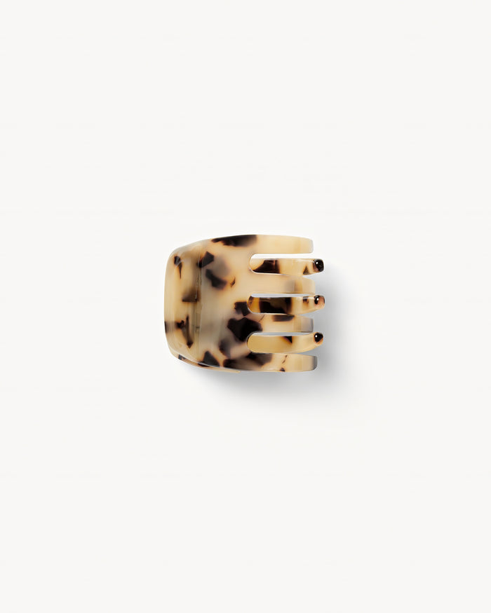 Off-model top-down view of the Machete Mini Claw in blonde tortoise showing the teeth and cream acetate with dark tortoise spots.