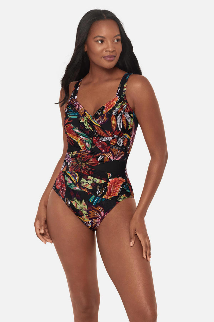Woman wearing a multicolored floral printed one-piece swimsuit with mesh cutouts