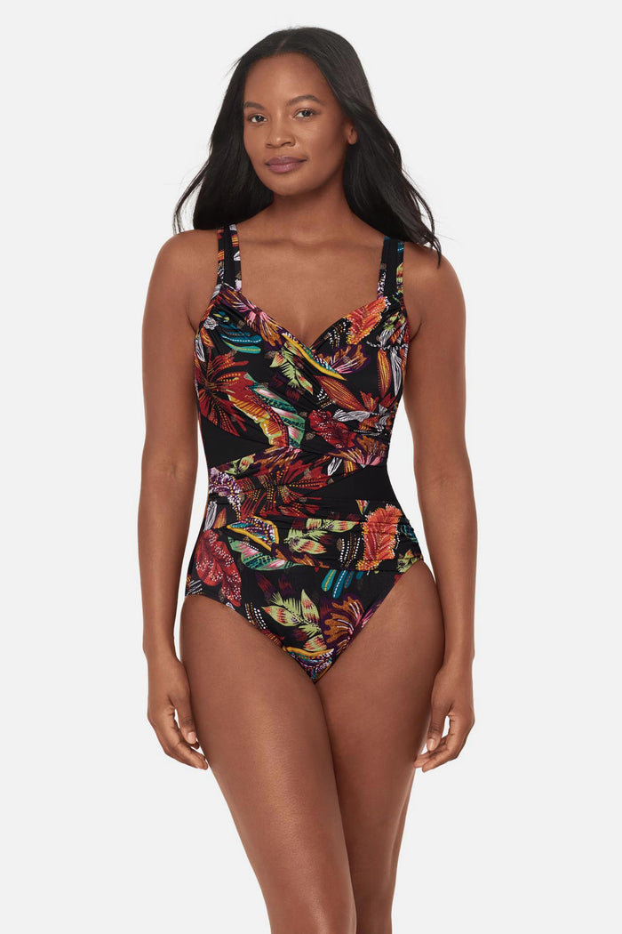 Woman wearing a multicolored floral printed one-piece swimsuit with mesh cutouts